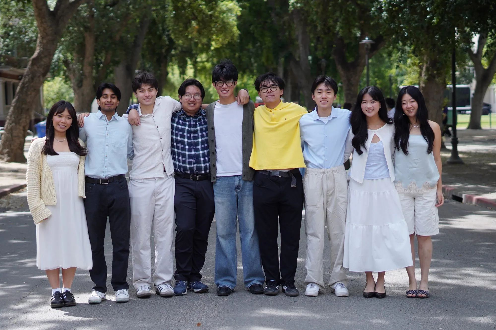 The Moober team, ten students standing arm in arm on a tree-lined path.
